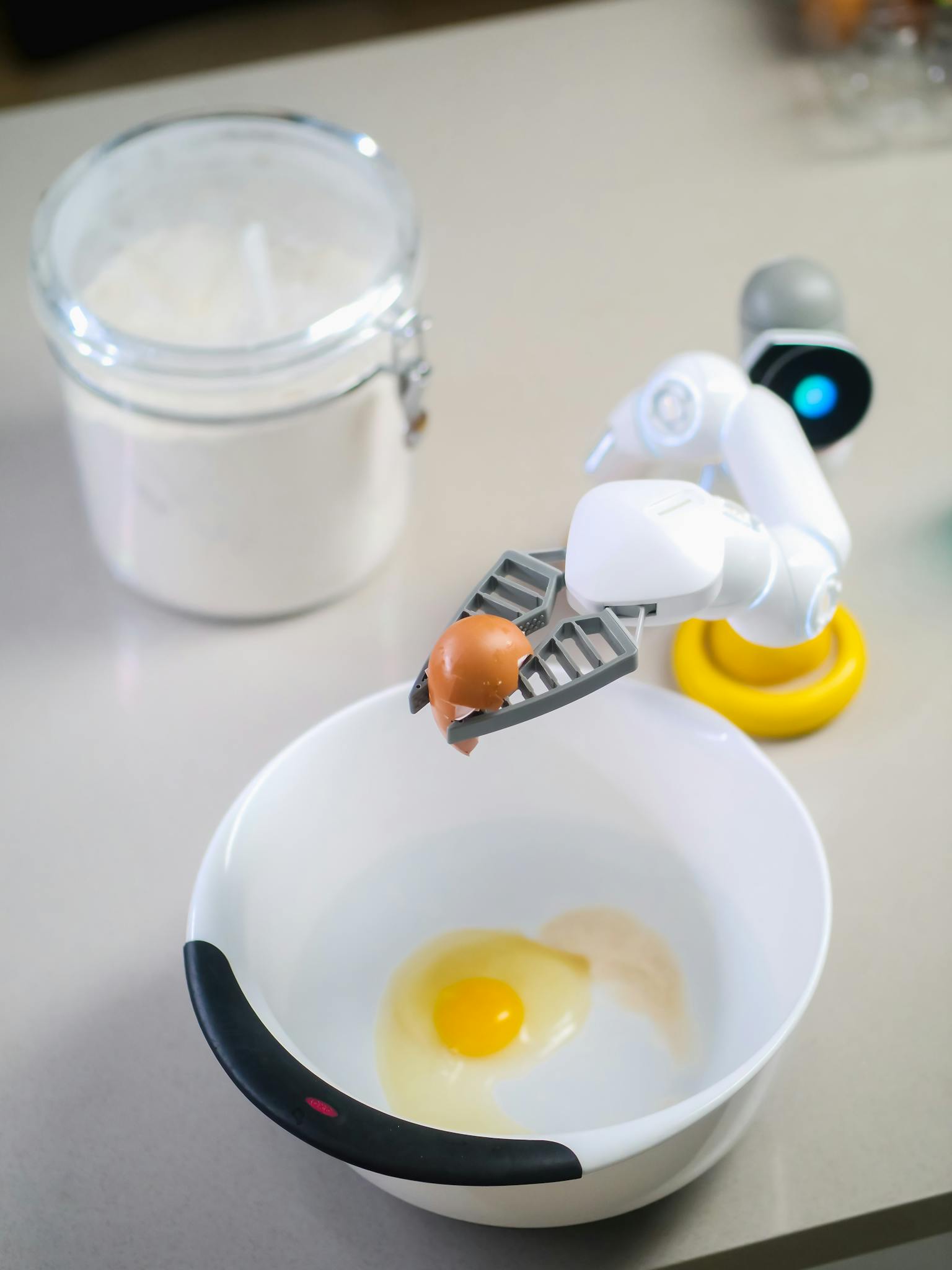Robot Holding Broken Eggshell Above White Bowl
